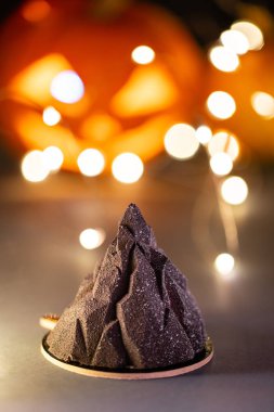 Siyah Dağ. Cadılar Bayramı korkutucu mousse kek ile arka plan üzerinde kabak canavar. Garland ışıklar