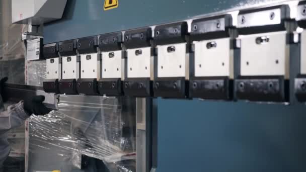 Tillverka verkstad. Arbetstagare justerar maskinen i lagret. produktionen av ventilation och rännor. Verktyg och böjande utrustning för plåt. — Stockvideo