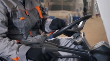 -direksiyon simidi ve kollarını kapatın. adam bir fabrikada bir ambar yoluyla forklift sürüş. sürücü düzgün ve koruyucu kask içinde. Lojistik ve depolama kavramı
