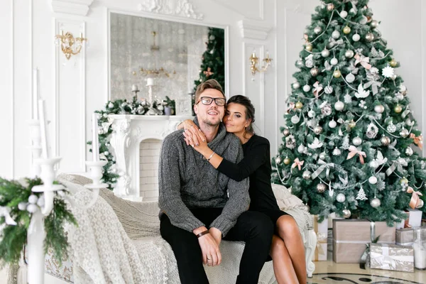 Mladý pár. Šťastná rodina baví doma. Vánoční dopoledne v obývací pokoj. Šťastný nový rok. zdobené vánoční strom — Stock fotografie