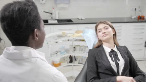 Joven hermosa chica en la silla del dentista en la clínica dental. Medicina, salud, concepto estomatológico. dentista tratando a un paciente. Mujer sonriendo — Vídeos de Stock