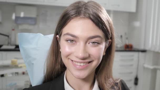 Retrato de una joven hermosa en la silla del dentista en la clínica dental. Medicina, salud, concepto estomatológico. dentista tratando a un paciente. Mujer sonriendo — Vídeos de Stock