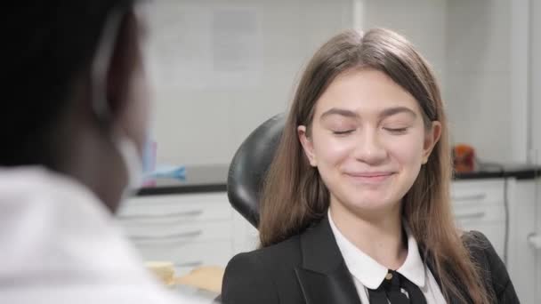 Portrait of a young beautiful girl in the dentist chair at dental clinic. Medicine, health, stomatology concept. dentist treating a patient. Woman smiling — Stock Video