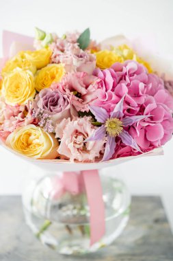 güzel bahar buket. çeşitli renk eski masada cam vazoda çiçek aranjman. parlak oda, beyaz duvar. kopya alanı