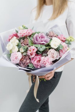 güzel bahar buket. Bir çiçek düzenlemeleri çeşitli renklerin tutan genç kız. beyaz duvar.