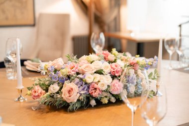 güzel çiçek aranjmanı. Düğün ya da gala yemeği. Sandalye ve masa için konuklar, çatal bıçak takımı ve çanak çömlek ile servis edilir.