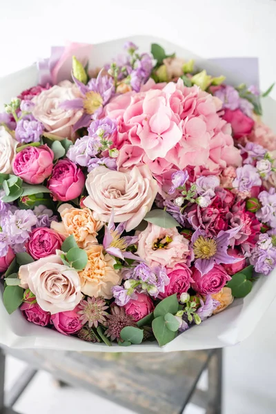 Lindo buquê de primavera. arranjo de flores com várias cores em vaso de vidro na mesa velha. Quarto luminoso, parede branca. espaço de cópia — Fotografia de Stock