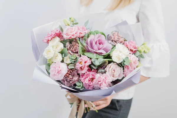 Lindo buquê de primavera. Menina segurando um arranjos de flores com várias cores. parede branca . — Fotografia de Stock