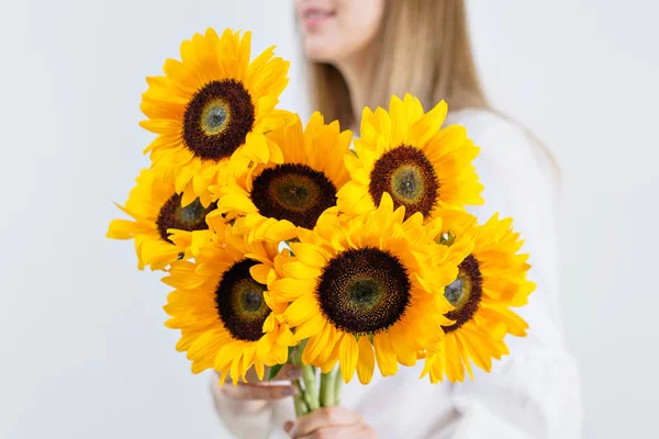 Boeket van gele zonnebloemen, bloem in de hand van de vrouw. Kamer ochtend. Kleuren van de herfst en stemmingsstoornissen vallen — Stockfoto