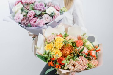 iki güzel bahar buket. Bir çiçek düzenlemeleri çeşitli renklerin tutan genç kız. beyaz duvar.