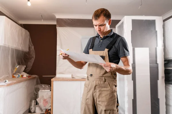Fokuserade flitiga arbetare inspektera rummet och reparationer planeringsarbete. reparation av matsalen i huset, köksmöbler, golvbeläggningen i förändring — Stockfoto