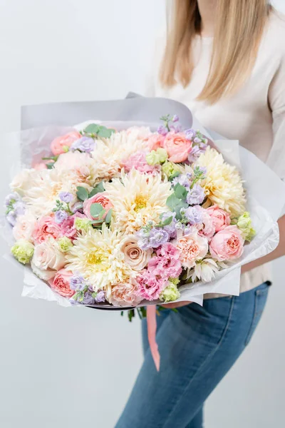 Gyönyörű tavaszi csokor női kézben. Megállapodás a különböző virágok. A virágüzlet koncepciója. Fényképek egy webhelyhez vagy katalógushoz. Munkahelyi virágárus. — Stock Fotó