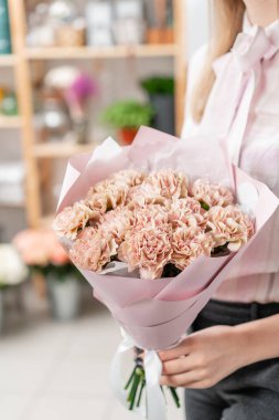 Bir buket karanfil çiçeği pastel rengi. Bahar demeti kadınların elinde. Anneler Günü için hediye.