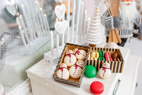 Ποικιλία από γλυκά αμυγδαλωτά σε χάρτινο κουτί. Μπισκότο, με τη μορφή έναν χιονάνθρωπο. Χαρούμενα Χριστούγεννα κάρτα. Διάθεση νέο έτος. φώτα γιρλάντα βολβών — Φωτογραφία Αρχείου