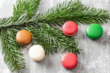 Neşeli Noel kartı. Çeşitli tatlı macaroons ve çam dalları gri antika arka plan üzerinde. düz yatıyordu, en iyi görünüm. Yeni yıl ruh hali