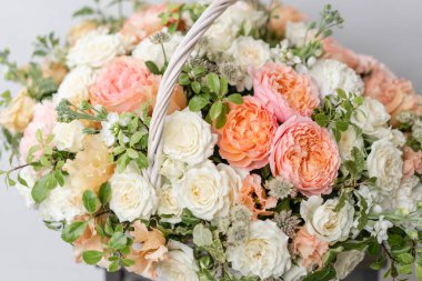 Hasır sepet ile gri duvarının yakınında ahşap masaya güzel çiçek karıştırın. Güzel bahçe çiçek düzenleme, profesyonel çiçekçi iş. Avrupa çiçek dükkanı