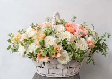 Hasır sepet ile gri duvarının yakınında ahşap masaya güzel çiçek karıştırın. Güzel bahçe çiçek düzenleme, profesyonel çiçekçi iş. Avrupa çiçek dükkanı