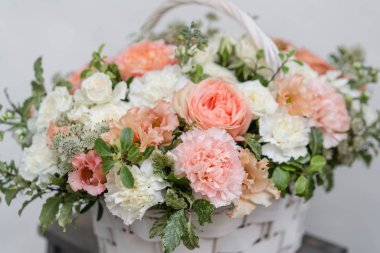 Hasır sepet ile gri duvarının yakınında ahşap masaya güzel çiçek karıştırın. Güzel bahçe çiçek düzenleme, profesyonel çiçekçi iş. Avrupa çiçek dükkanı