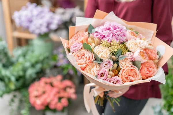 Tienda floral europea. Ramo de hermosas flores mixtas en mano de mujer. Excelentes flores de jardín en el arreglo, el trabajo de un florista profesional . — Foto de Stock
