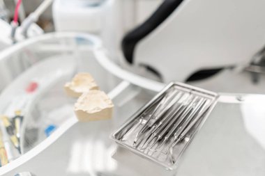 Dişçi kliniğindeki stomatolojik aletler. Klinikte dişçilik. Ameliyat, diş protezi. Tıp, sağlık, stomatoloji konsepti. Diş hekiminin teftiş yaptığı ve sonuca vardığı ofis..