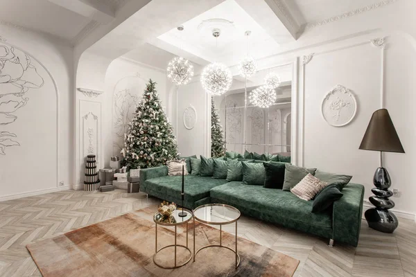 Jul kväll. klassiska lyxiga lägenheter med dekorerad julgran. Vardagsrum hall stor spegel, grön soffa, höga fönster, kolumner och stuckatur. — Stockfoto