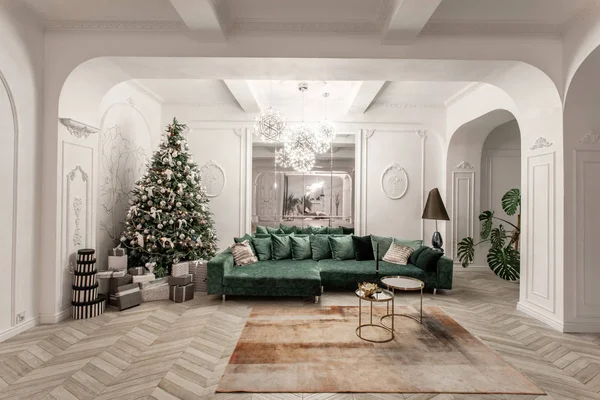 Weihnachtsabend. klassische luxuriöse Apartments mit geschmücktem Weihnachtsbaum. Wohnzimmer großer Spiegel, grünes Sofa, hohe Fenster, Säulen und Stuck. — Stockfoto