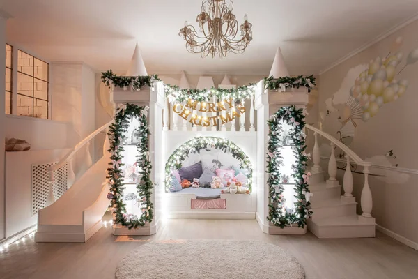 Noche de Navidad. Interior de una espaciosa habitación para niños. castillo decorativo con cama en el interior, diapositiva de juego y escaleras — Foto de Stock