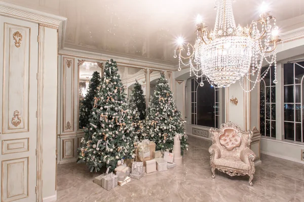 Noche de Navidad. apartamentos de lujo clásicos con árbol de Navidad decorado. Salón gran espejo, silla, ventanas altas, columnas y estuco . — Foto de Stock