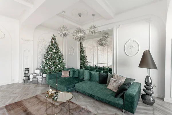 Mañana de Navidad. apartamentos de lujo clásicos con árbol de Navidad decorado. Salón gran espejo, sofá verde, ventanas altas, columnas y estuco . — Foto de Stock