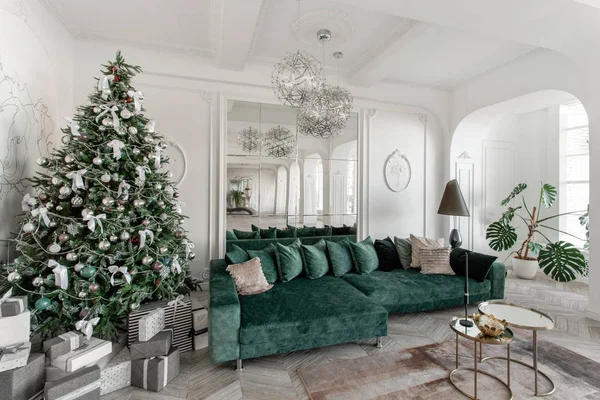 Juldagens morgon. klassiska lyxiga lägenheter med dekorerad julgran. Vardagsrum hall stor spegel, grön soffa, höga fönster, kolumner och stuckatur. — Stockfoto