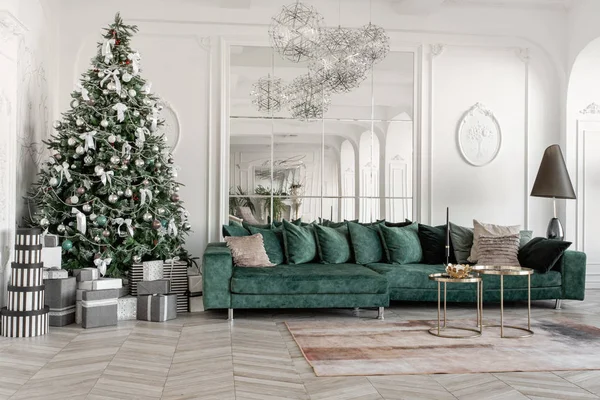 Mañana de Navidad. apartamentos de lujo clásicos con árbol de Navidad decorado. Salón gran espejo, sofá verde, ventanas altas, columnas y estuco . — Foto de Stock