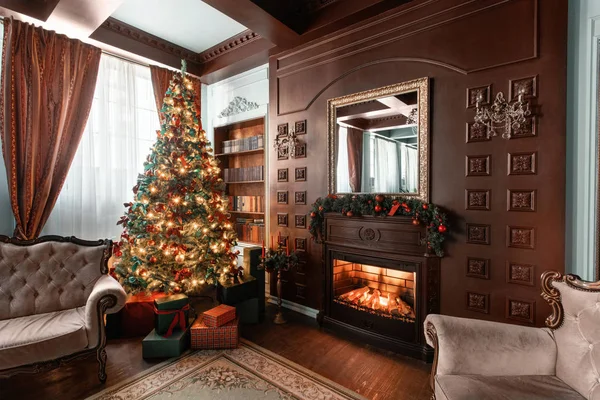 Mañana de Navidad. Regalos en el árbol de Navidad. Apartamentos clásicos con chimenea. Habitación con estantes de libros —  Fotos de Stock