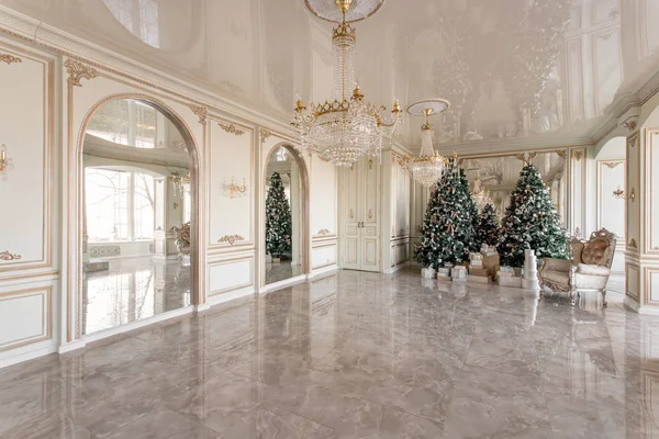 Vánoční ráno. Klasické luxusní apartmány s nazdobený vánoční stromeček. Obývací hala velké zrcadlo, křeslo, vysokými okny, sloupy a štuk. — Stock fotografie