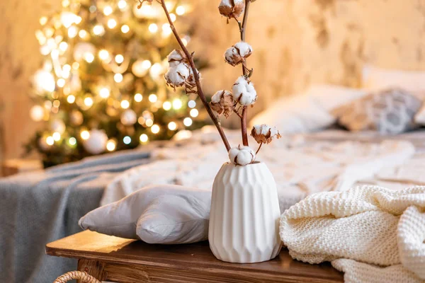 Florero con ramas de algodón. Apartamentos estilo loft, árbol de Navidad. Cama en el dormitorio, grandes ventanales — Foto de Stock