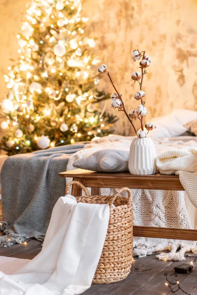 Vase mit Baumwollzweigen vorhanden. Wohnungen im Loft-Stil, Weihnachtsbaum. Bett im Schlafzimmer, hohe große Fenster — Stockfoto