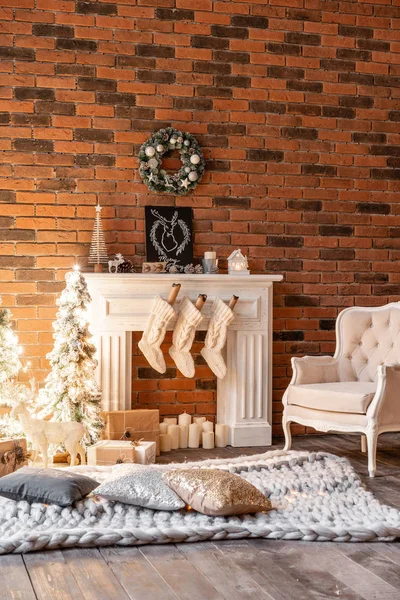 Loft apartments, tegelvägg med ljus och julgran krans. Vit ull strumpor för Santa på spisen. Stickade matta och stol, julgran — Stockfoto