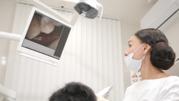 El dentista examina con macro cámara la cavidad oral del paciente. Joven paciente afroamericano en silla en la clínica dental. Medicina, salud, concepto de estomatología . — Vídeo de stock