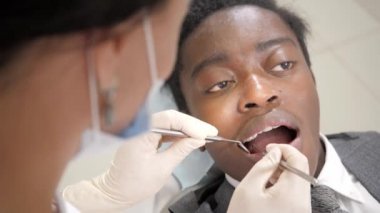 Kadın diş hekimi hastaya davranır. Genç Afro-Amerikan erkek hasta sandalyeye diş kliniği. Tıp, sağlık, stomatology kavramı.