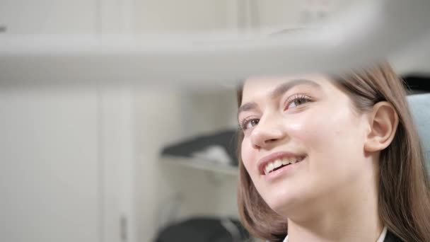 Retrato de una joven hermosa en la silla del dentista en la clínica dental. Medicina, salud, concepto estomatológico. dentista tratando a un paciente. Mujer sonriendo — Vídeos de Stock