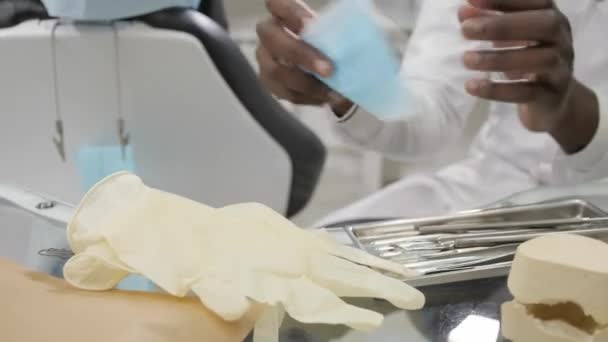 Se pone una máscara médica. Joven médico afroamericano dentista. Medicina, salud, concepto estomatológico. dentista realiza inspección y concluye — Vídeos de Stock