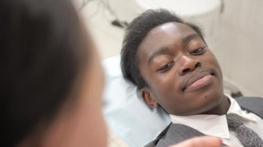 Kadın diş hekimi inceler ve hasta danışır. Genç Afro-Amerikan erkek hasta sandalyeye diş kliniği. Tıp, sağlık, stomatology kavramı.