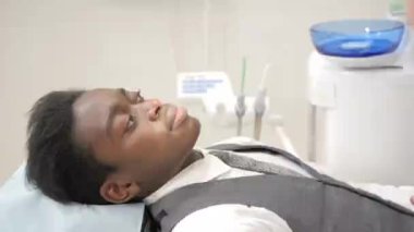 Kadın diş hekimi inceler ve hasta danışır. Genç Afro-Amerikan erkek hasta sandalyeye diş kliniği. Tıp, sağlık, stomatology kavramı.