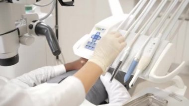 Büyüleyici güzel kız doktor diş hekimi. Genç Afro-Amerikan erkek hasta sandalyeye diş kliniği. Tıp, sağlık, stomatology kavramı. diş hekimi muayene yapar ve bitirmek.