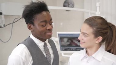 Güzel bir kadın doktor diş hekimi. Genç Afro-Amerikan erkek hasta. Tıp, sağlık, stomatology kavramı. diş hekimi muayene yapar ve bitirmek