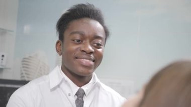 Genç Afro-Amerikan erkek doktor diş hekimi. Sandalye, Diş Kliniği, güzel kız hasta. Tıp, sağlık, stomatology kavramı. diş hekimi muayene yapar ve bitirmek