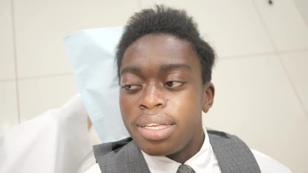 Mulher dentista examina e consulta a paciente. Jovem afro-americano na cadeira da clínica dentária. Medicina, saúde, conceito de estomatologia . — Vídeo de Stock