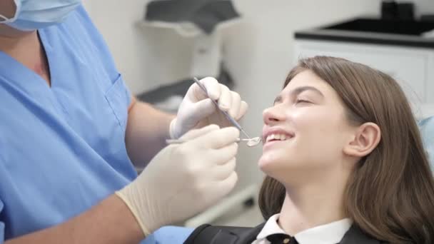 Diş Kliniği, dişçi sandalyede güzel bir genç kız portresi. Tıp, sağlık, stomatology kavramı. bir hastayı tedavi diş hekimi. — Stok video