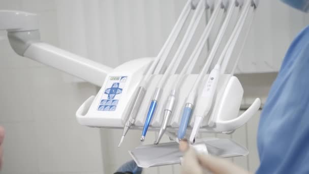 Il dentista prende lo strumento, giovane bella ragazza sulla sedia del dentista presso la clinica dentistica. Medicina, salute, concetto di stomatologia. dentista che cura un paziente . — Video Stock