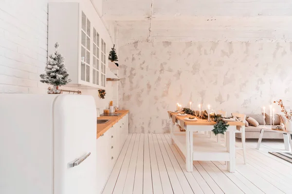 ロフト スタイルのアパートメント、ダイニング テーブルとキッチンの大きな広々 としたリビング ルーム。クリスマス ツリーが客室です。快適なソファー、高く大きな窓。光の白いレンガの壁. — ストック写真
