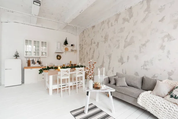 Appartamento in stile loft, ampio soggiorno spazioso con tavolo da pranzo e cucina. Camera con albero di Natale. Comodo divano, finestre alte e grandi. Luce muro di mattoni bianchi . — Foto Stock